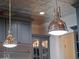 Close up of industrial-style pendant lights with a metallic ceiling above the kitchen cabinets at 9916 Lone Tree Ln, Orlando, FL 32836