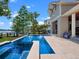 Sparkling pool surrounded by travertine tile and meticulous landscaping, with lake views and dock at 9916 Lone Tree Ln, Orlando, FL 32836