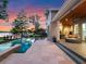 Stunning sunset view of the pool, patio and lake from the backyard of this beautiful home at 9916 Lone Tree Ln, Orlando, FL 32836