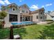Attractive rear exterior with a spacious patio, pool, and waterfront view, ideal for entertaining at 9916 Lone Tree Ln, Orlando, FL 32836