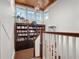 Upper staircase landing with high ceilings, natural light, built-in bookcase and wood railing with white banisters at 9916 Lone Tree Ln, Orlando, FL 32836