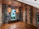 Glass enclosed wine cellar featuring stone and wood walls, stylish wine racks, and hardwood floors at 9916 Lone Tree Ln, Orlando, FL 32836