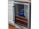 Modern wine fridge with glass door, wooden shelving, and sleek design at 9916 Lone Tree Ln, Orlando, FL 32836