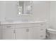 Bright bathroom featuring white vanity with granite countertop, single sink, and modern mirror at 10371 Kensington Shore Dr # H-201, Orlando, FL 32827