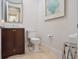 Well-lit bathroom with a dark wood vanity, marble countertop, and decorative accents at 10371 Kensington Shore Dr # H-201, Orlando, FL 32827