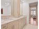 Bright bathroom with dual sinks, granite countertop, modern mirrors, and open doorway at 10371 Kensington Shore Dr # H-201, Orlando, FL 32827