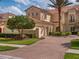 Elegant exterior showcasing the brick driveway, manicured lawn, and the beautiful architecture of the home at 10371 Kensington Shore Dr # H-201, Orlando, FL 32827