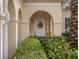 Charming front entry features an arched doorway, decorative wreath, and lush landscaping at 10371 Kensington Shore Dr # H-201, Orlando, FL 32827