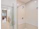 Bright bathroom featuring glass-enclosed shower with white tiled walls and showerhead at 10371 Kensington Shore Dr # H-201, Orlando, FL 32827