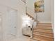 Bright foyer with modern staircase, mirrored chest, stylish light fixture, and decorative artwork at 10371 Kensington Shore Dr # H-201, Orlando, FL 32827