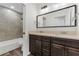 A bathroom featuring a double vanity with dark cabinets, tub, and glass shower at 1040 20Th St, Orlando, FL 32805