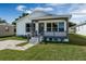 Inviting home exterior showcasing a covered porch with updated railing and tidy landscaping at 1040 20Th St, Orlando, FL 32805