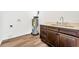 This laundry room features beautiful wood-look flooring and rich, dark wood cabinetry topped with light countertops at 1040 20Th St, Orlando, FL 32805