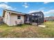 This backyard features a cozy screened-in patio with a hot tub, outdoor seating, and a well-manicured lawn at 10934 Tangora St, Orlando, FL 32825