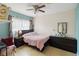 This bedroom features modern ceiling fan, dark furnishings, and ample natural light at 10934 Tangora St, Orlando, FL 32825