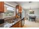 Functional kitchen featuring granite countertops, stainless steel appliances, and adjacent dining room with backyard view at 10934 Tangora St, Orlando, FL 32825