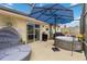Relax on this screened in patio featuring a hot tub, sunshade, and outdoor seating at 10934 Tangora St, Orlando, FL 32825