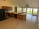 Open kitchen featuring stainless steel appliances, tile floors, light countertops, and wood cabinets at 1115 Fidelma Ct, Orlando, FL 32824