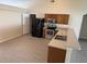 Bright kitchen featuring stainless steel appliances, wood cabinets, tile floors, and light countertops at 1115 Fidelma Ct, Orlando, FL 32824