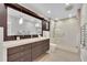 Bathroom showcasing a double sink vanity with a large mirror and a glass-enclosed shower at 1130 Washington Ave # 11, Winter Park, FL 32789