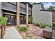 A close exterior shot featuring a townhouse entrance with red brick, a small patio, and manicured greenery at 1130 Washington Ave # 11, Winter Park, FL 32789