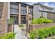 Eye-level angle showcasing the brick facade of a townhouse, emphasizing its landscaped entrance at 1130 Washington Ave # 11, Winter Park, FL 32789