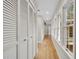 Hallway with wood floors, a wall of closets, and windows providing natural light at 1130 Washington Ave # 11, Winter Park, FL 32789