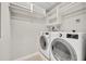 Laundry room with side-by-side washer and dryer and built-in shelving for storage at 1130 Washington Ave # 11, Winter Park, FL 32789