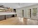 Bright living room featuring light wood floors, custom built-in shelves and cabinetry, and French doors to the outdoor living space at 1130 Washington Ave # 11, Winter Park, FL 32789