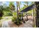 Outdoor wooden deck featuring a pergola and tropical landscaping provides a relaxing outdoor space at 1200 Auger Dr, New Smyrna Beach, FL 32168