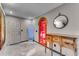 Bright entryway featuring a unique red-tinted door, decorative water feature, and rustic wood console table at 1200 Auger Dr, New Smyrna Beach, FL 32168