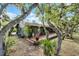 This home features a large wooden deck, tropical landscaping, and mature trees with Spanish Moss, creating a serene backyard retreat at 1200 Auger Dr, New Smyrna Beach, FL 32168