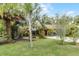 View of the home and the outdoor seating area, surrounded by mature landscaping and a well-maintained lawn at 1200 Auger Dr, New Smyrna Beach, FL 32168