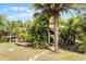 Backyard tropical paradise featuring a wooden deck, mature trees and lush landscaping, creating a serene outdoor retreat at 1200 Auger Dr, New Smyrna Beach, FL 32168