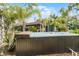 Enjoy relaxing in the hot tub, surrounded by lush tropical plants and mature trees in this backyard oasis at 1200 Auger Dr, New Smyrna Beach, FL 32168