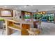 Spacious kitchen with custom island featuring wood accents, bar stool seating and view to living area at 1200 Auger Dr, New Smyrna Beach, FL 32168