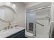 Well-lit bathroom featuring a vanity, round mirror, and glass-enclosed shower stall at 1210 Maury Rd # 3, Orlando, FL 32804