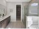 Elegant bathroom featuring dual vanities, a glass-enclosed shower, and modern fixtures at 12966 Promise Pl, Orlando, FL 32832