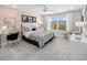 Stylish bedroom features a large window, a modern desk, and soothing pink walls for a peaceful retreat at 12966 Promise Pl, Orlando, FL 32832