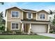 Charming two-story home with shake siding and a well-manicured lawn at 12966 Promise Pl, Orlando, FL 32832