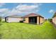 View of the back of the home, screened in porch, and spacious green lawn at 145 Palazzo Ln, Kissimmee, FL 34759