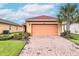 Charming single-story home featuring a brick driveway, lush landscaping, and a two-car garage at 145 Palazzo Ln, Kissimmee, FL 34759