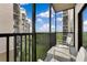 Balcony with seating offers views of lush landscaping and surrounding buildings on a sunny day at 14501 Grove Resort Ave # 2438, Winter Garden, FL 34787