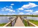 Scenic dock with boat slips and a covered pavilion on a calm lake under a partly cloudy sky at 14501 Grove Resort Ave # 2438, Winter Garden, FL 34787