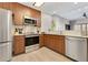 Modern kitchen with stainless steel appliances, wood cabinets, and an open layout to the living area at 14501 Grove Resort Ave # 2438, Winter Garden, FL 34787