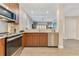 Stylish kitchen with stainless steel appliances and wood cabinets that opens to the living area at 14501 Grove Resort Ave # 2438, Winter Garden, FL 34787