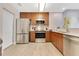 Well-equipped kitchen featuring stainless steel appliances, wood cabinetry, and light countertops at 14501 Grove Resort Ave # 2438, Winter Garden, FL 34787