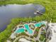 Aerial view of the multi-pool resort area, with lush landscaping, sun loungers, and relaxation spaces by the lake at 14501 Grove Resort Ave # 2438, Winter Garden, FL 34787