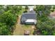 An aerial view of the property, showcasing the backyard, covered patio, storage shed and surrounding trees at 1550 Maxwell Ln, Deltona, FL 32738