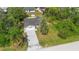 An aerial view of the property showcasing its well maintained lawn, mature trees, and long driveway at 1550 Maxwell Ln, Deltona, FL 32738